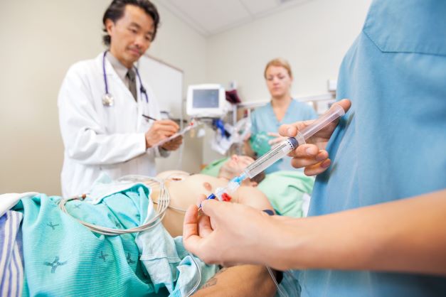 Medical staff documenting medication dosage while administering to patient