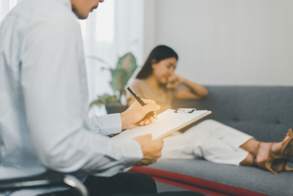 Professional psychiatrist talking and assessing woman patient