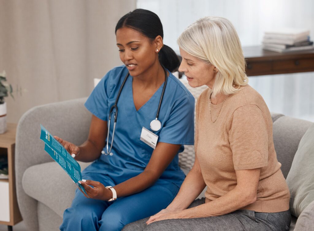 Healthcare staff reviewing vaccine information sheet with patient.