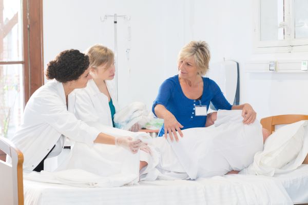 Nurses observing training for care of a patient.