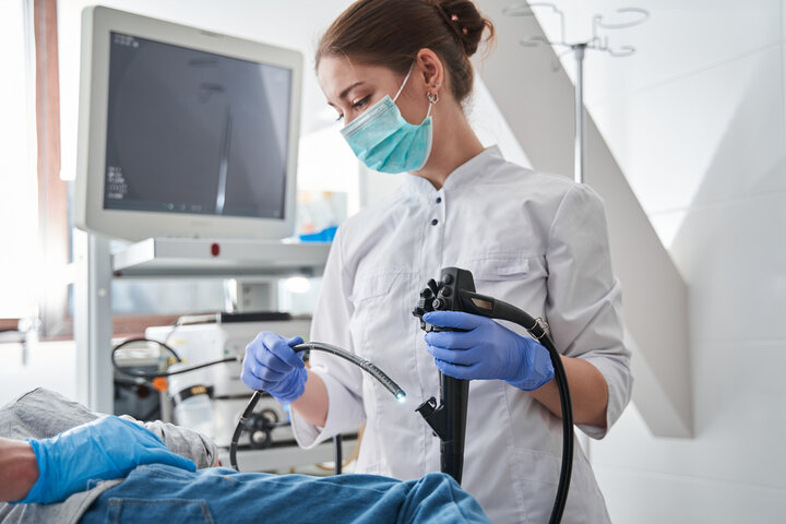 Surgeon using endoscope for surgical procedure.