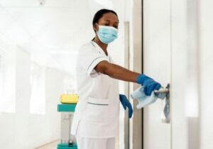 nurse cleaning door handle in hospital